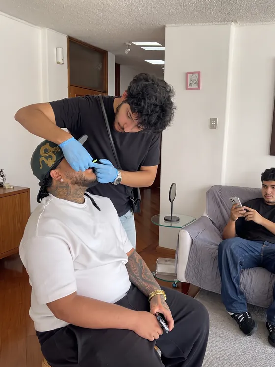Ezzy tomando la impresión dental a un cliente en el taller
